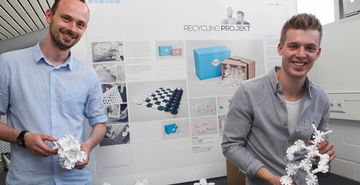 Diese zwei Personen halten ein Steckpuzzel in den Händen, das aus Abfällen der W. Brodhage OHG angefertigt wurde.