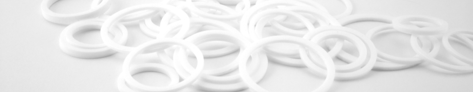 Weiße, runde Kunststoffringe (Ploycel) teils übereinander, teils nebeneinander gestapelt - aus unserem Produktsortiment